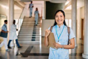 Porträt einer glücklichen asiatischen Krankenpflegeschülerin an einer medizinischen Universität blickt in die Kamera.