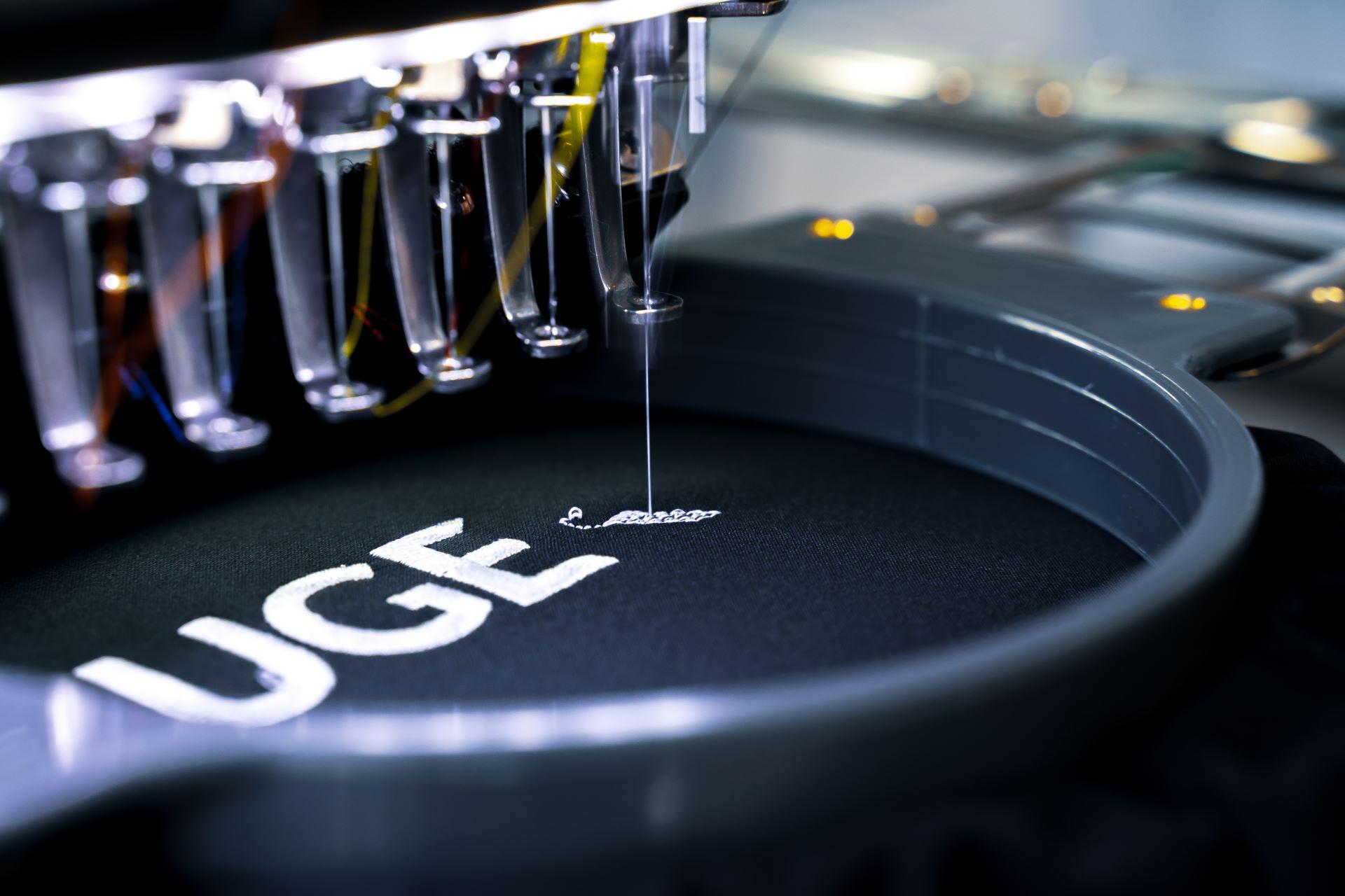 Detailaufnahme einer Stickmaschine beim Besticken eines Logos