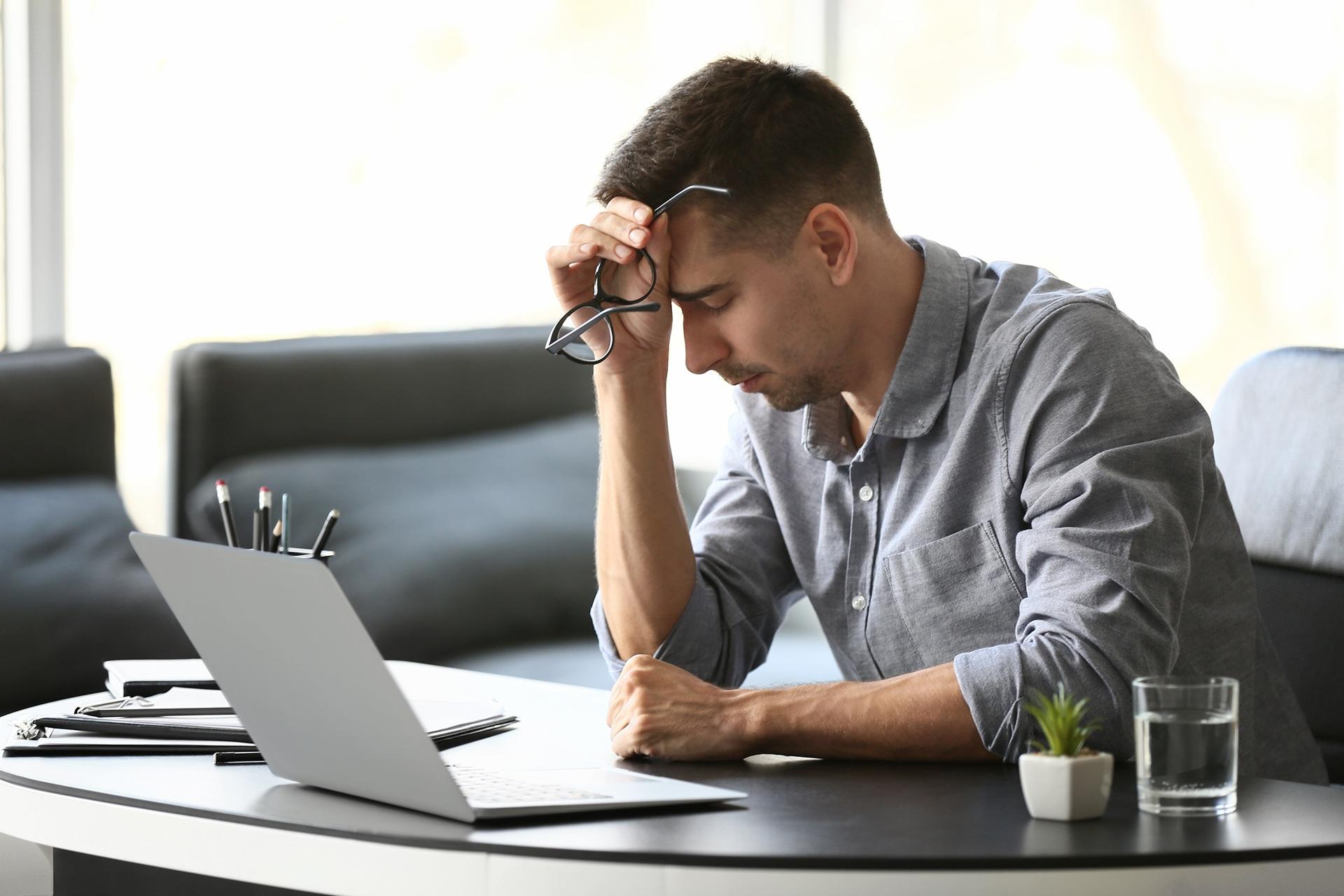 Gestresster Mann am Schreibtisch sitzt | EmployeeAssistanceProgram