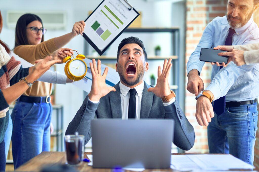 Gestresster Mann von Aufgaben umgeben | EmployeeAssistanceProgram